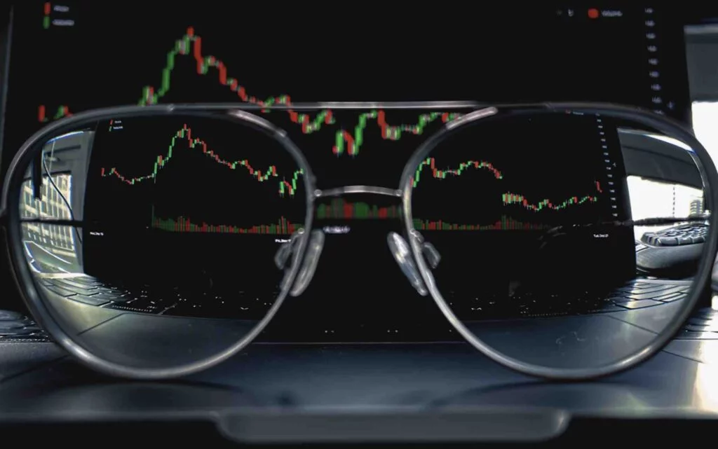 TradingView platform in dark mode with a pair of glasses in front of it